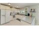 Bright kitchen featuring white appliances, cabinets, and countertops, with tiled flooring at 18082 Eau Gallie S Cir, Port Charlotte, FL 33948