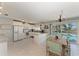 Bright kitchen and dining area featuring white cabinets and access to the screened pool deck at 18082 Eau Gallie S Cir, Port Charlotte, FL 33948