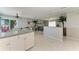 Bright open kitchen with tiled flooring, modern lighting, and an island with seating and a view of the living room at 18082 Eau Gallie S Cir, Port Charlotte, FL 33948