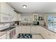 Bright kitchen featuring white appliances and cabinets, with a view of the screened pool area at 18082 Eau Gallie S Cir, Port Charlotte, FL 33948