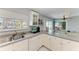 Bright kitchen featuring white cabinets and countertops, with a view of the screened pool area at 18082 Eau Gallie S Cir, Port Charlotte, FL 33948
