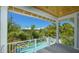 Balcony view of a beautiful swimming pool and lush tropical landscape from the second story at 212 Spring Ave, Anna Maria, FL 34216