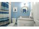 Charming bathroom with a porthole mirror, blue accents, and a coordinated shower curtain at 212 Spring Ave, Anna Maria, FL 34216