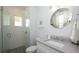 Bright bathroom featuring a nautical round mirror, patterned floor tiles, and a walk-in shower at 212 Spring Ave, Anna Maria, FL 34216