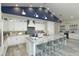 Modern kitchen featuring white cabinets, stainless steel appliances, large island with seating and stylish back splash at 212 Spring Ave, Anna Maria, FL 34216