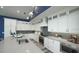 Modern kitchen featuring white cabinets, stainless steel appliances, and stylish backsplash and light blue wall at 212 Spring Ave, Anna Maria, FL 34216