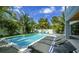 Inviting swimming pool with lounge chairs and beach towels surrounded by lush tropical vegetation at 212 Spring Ave, Anna Maria, FL 34216