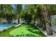 Putting green near the pool, surrounded by palm trees and lush landscaping at 212 Spring Ave, Anna Maria, FL 34216