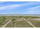 Expansive beach view with vegetation leading to the white sand and beautiful ocean waters at 216 Tenacity Ln, Sarasota, FL 34242