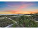 Stunning sunset over the sandy beach with lush vegetation and palm trees at 216 Tenacity Ln, Sarasota, FL 34242