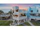 Stunning beachfront property features unique architecture, an elevated design, a spiral staircase, and verdant lawn at 216 Tenacity Ln, Sarasota, FL 34242