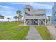 Coastal home with elevated design, featuring a walkway to the beach and lush landscaping, blending style and nature at 216 Tenacity Ln, Sarasota, FL 34242