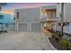 Charming beach house boasts a two-car garage and convenient under-house parking, complemented by lush greenery at 216 Tenacity Ln, Sarasota, FL 34242