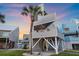 Eye-catching elevated beach house with stylish decks, a spiral staircase, and lush landscaping, ideal for coastal living at 216 Tenacity Ln, Sarasota, FL 34242