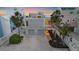 Coastal home features two-car garage, elevated design, and lush landscaping, offering a serene beachfront lifestyle at 216 Tenacity Ln, Sarasota, FL 34242