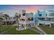 Striking coastal home with a modern design, elevated layout, balcony, and lush green lawn, perfect for beach living at 216 Tenacity Ln, Sarasota, FL 34242