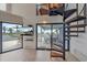 Living room with spiral stairs, television, and sliding glass doors that lead to a deck at 216 Tenacity Ln, Sarasota, FL 34242