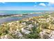 Aerial view showcases a house surrounded by trees and a water view in the background at 2165 Lemon Ave, Englewood, FL 34223