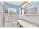 Bright bathroom with seashell wallpaper, white tile, and double sink vanity at 2165 Lemon Ave, Englewood, FL 34223