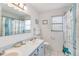 Well-lit bathroom with blue accents features double sinks and a shower/tub combination at 2165 Lemon Ave, Englewood, FL 34223