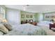 Spacious green bedroom with two beds, seating, and ample closet space at 2165 Lemon Ave, Englewood, FL 34223