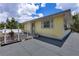 The roof of the yellow building with grey shingles has a small deck and fenced area at 2165 Lemon Ave, Englewood, FL 34223