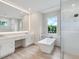 Modern bathroom featuring a soaking tub, glass shower, double vanity, and bright natural light at 2319 Webber St, Sarasota, FL 34239