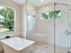 Contemporary bathroom featuring a glass shower, soaking tub, and natural light at 2319 Webber St, Sarasota, FL 34239