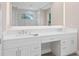 Elegant bathroom with double sinks, white cabinets, and a large, well lit mirror at 2319 Webber St, Sarasota, FL 34239