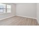A light and airy bedroom features wood-look tile flooring and a large picture window at 2319 Webber St, Sarasota, FL 34239