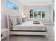 Bright bedroom with a large window, tray ceiling, and view of the screened-in pool area at 2319 Webber St, Sarasota, FL 34239