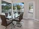 Elegant dining room with glass table, leather chairs, and a view of the screened-in pool area at 2319 Webber St, Sarasota, FL 34239