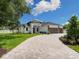 Beautiful home with a three-car garage and a circular driveway, surrounded by lush greenery and a blue sky at 2319 Webber St, Sarasota, FL 34239