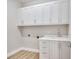 Laundry room with white cabinets, sink and faucet, and wood-look tile flooring at 2319 Webber St, Sarasota, FL 34239
