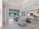 Bright living room with tile flooring, neutral furniture, and sliding glass doors to the pool area at 2319 Webber St, Sarasota, FL 34239