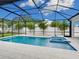 Screened pool with attached spa tub, white tile patio, and view of backyard at 2319 Webber St, Sarasota, FL 34239
