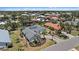 Beautiful aerial view of a modern home with a circular driveway, well-manicured landscaping, and a gray roof at 238 Lookout Point Dr, Osprey, FL 34229