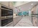 Open concept kitchen with stainless appliances, marble countertops, and large island flows into the living area at 238 Lookout Point Dr, Osprey, FL 34229