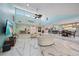 Spacious living room with high ceilings, a ceiling fan, stylish marble floors, and comfortable seating at 238 Lookout Point Dr, Osprey, FL 34229