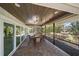 Covered brick patio features an outdoor dining area with a ceiling fan overlooking beautifully landscaped yard and fountain at 238 Lookout Point Dr, Osprey, FL 34229