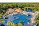 Aerial view shows a stunning community pool, clubhouse, playground, and a serene pond with a fountain at 246 Petrel Trl, Bradenton, FL 34212