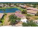 Aerial view of a home with a well-manicured lawn, mature trees, and lake views, showcasing curb appeal at 246 Petrel Trl, Bradenton, FL 34212