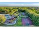 Aerial view of a community area featuring a pool, tennis and basketball courts, playground, clubhouse, and green space at 246 Petrel Trl, Bradenton, FL 34212