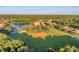 Aerial view of a lakeside community, featuring mature trees and a well-maintained baseball field at 246 Petrel Trl, Bradenton, FL 34212