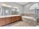 Bathroom featuring a soaking tub, walk-in shower, and a dual sink vanity at 246 Petrel Trl, Bradenton, FL 34212