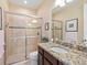 Bathroom featuring granite counters, a glass shower, and neutral tile at 2525 Vaccaro Dr, Sarasota, FL 34231