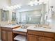 Bathroom with double vanities, soaking tub, glass shower, and linen closet at 2525 Vaccaro Dr, Sarasota, FL 34231