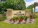 Elegant entrance sign for Esplanade by Siesta Key, surrounded by colorful flowers and lush landscaping at 2525 Vaccaro Dr, Sarasota, FL 34231