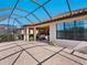Spacious screened patio complemented by manicured landscaping and a glimpse of the home's exterior at 2525 Vaccaro Dr, Sarasota, FL 34231