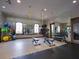 Modern fitness center with weights, benches, mirrors, TV, and rubber flooring for a safe workout environment at 2525 Vaccaro Dr, Sarasota, FL 34231